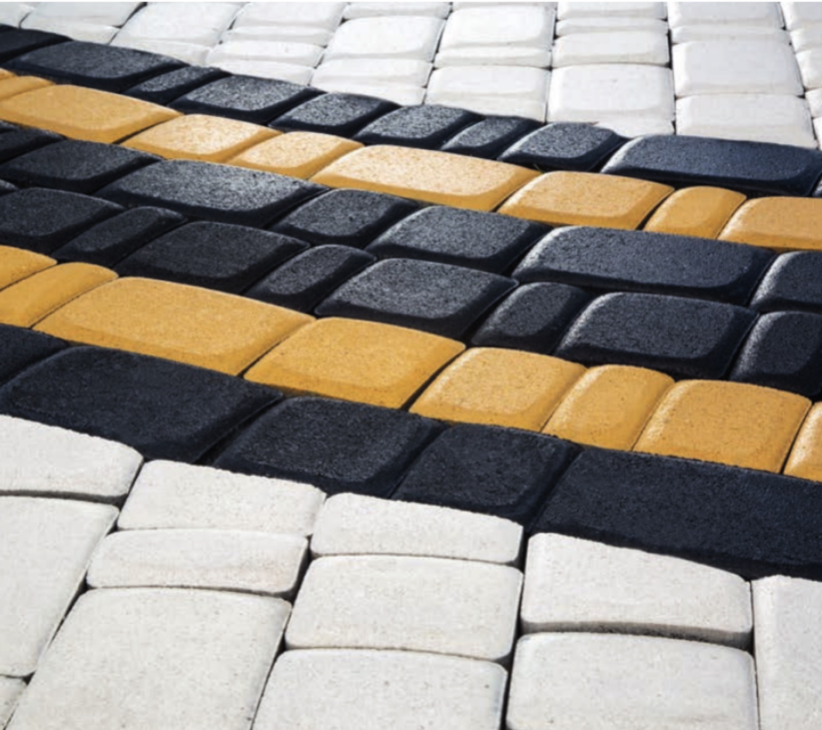 Close-up of ANTIK cobble pavers in white, black and yellow laid in straight bands