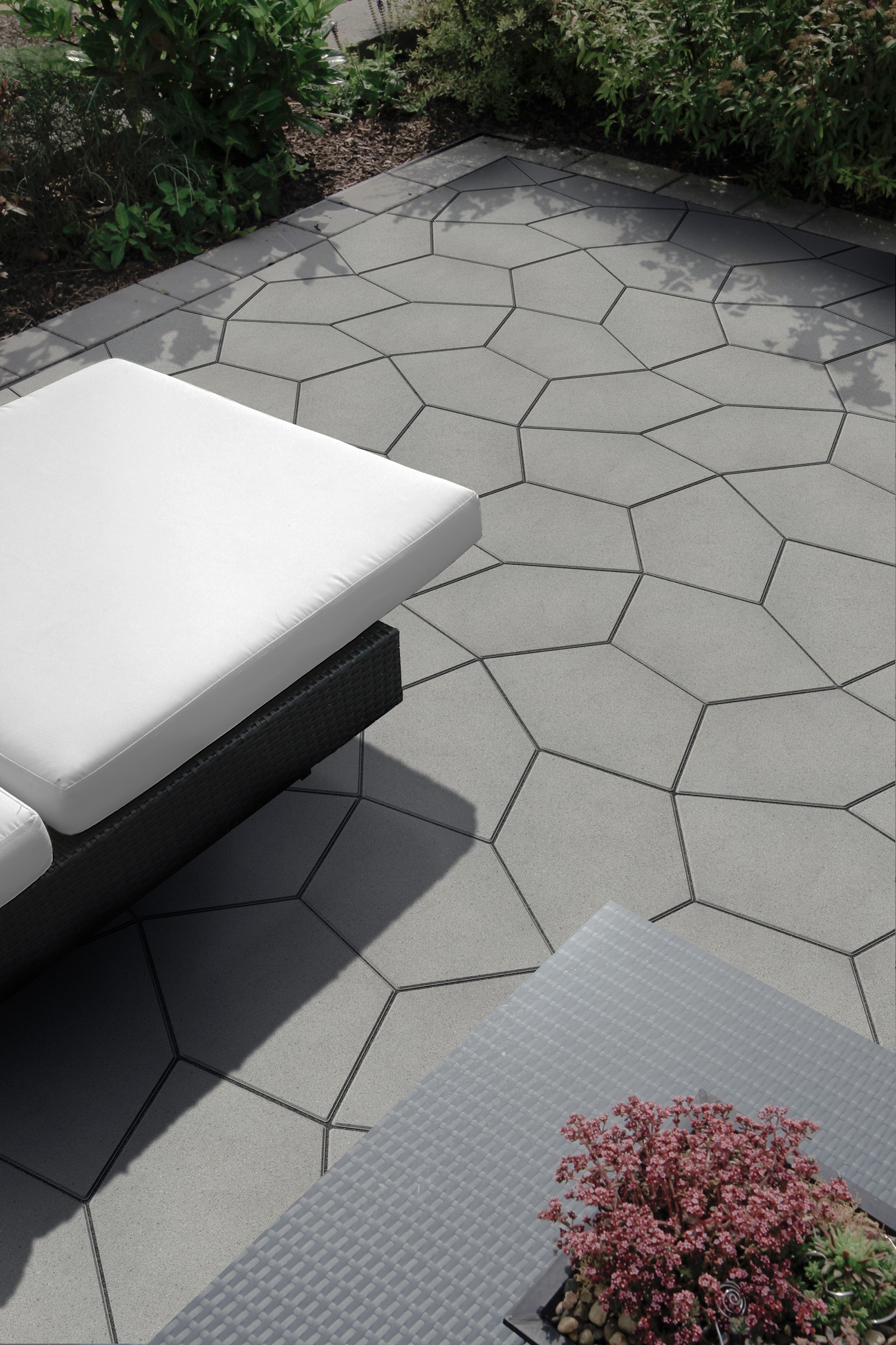 PENTA five-sided pavers across a garden terrace with a sun lounger and planting