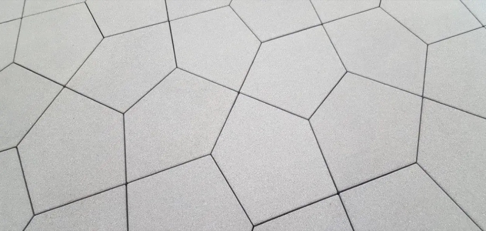 Close-up of PENTA five-sided pavers in plain light grey