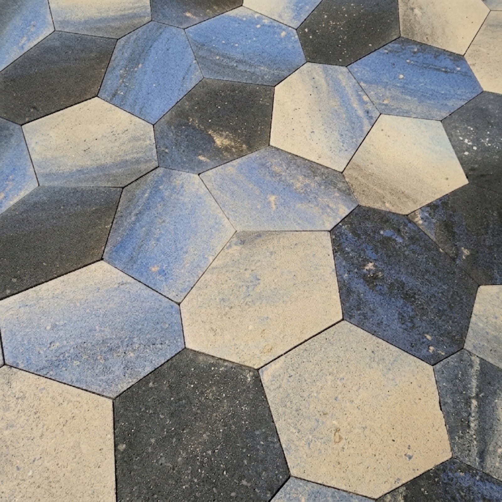 PENTA five-sided pavers in blue, beige and black set in rotating orientations